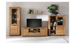Wohnwand bestehend aus Vitrine, Lowboard und Highboard mit Dekoration und zusätzlicher Beleuchtung vor einer farbig gestrichenen Wand.