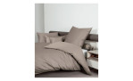 Mako-Satin Kissenbezug Colors, in der Größe 15 x 40 cm und in der Farbausführung beige, auf einem Bett bezogen mit der passenden Bettwäsche und weiteren Kissen