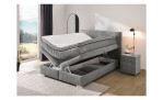 Boxspringbett Taro in der Farbe grau, in einem Raum stehend, mit zwei geöffneten Bettkästen