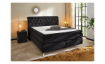 Boxspringbett Saragossa Max in einem samtähnlichen Stoff in der Farbe schwarz, in einem Raum stehend