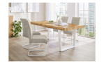 Schwingstuhl Kolding mit Bezug aus Cord-Stoff in beige und weißem Gestell im Esszimmer an einem Tisch.