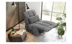 Relax-Sessel in grauem Cordstoff bezogen mit einem Zierkissen mit hochgestelltem Fußteil im Wohnzimmer.