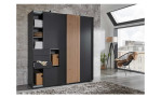 Schwebetürenschrank Conrad in der Farbausführung graphit mit einer Akustiklamelle in Artisan Eiche mit offener Tür, in einem Raum stehend mit Leuchten