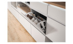 Schuhschrank Shoes mit 2 Klappen und 1 Schubkasten, in der Farbe Weiß und einem Oberboden in Nox Oak Nachbildung, Detailansicht mit geöffneter Klappe